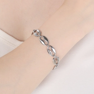 Close-up of silver coffee bean link bracelet in polished titanium steel on wrist