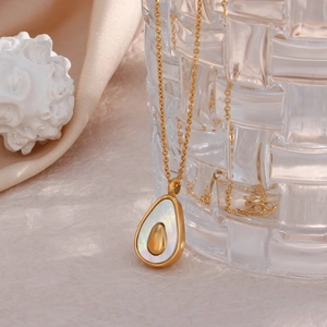 Detailed close-up of a gold avocado pendant necklace with white shell inlay for women