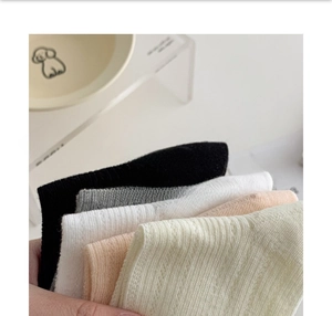 Vue détaillée de chaussettes en maille de coton pliées avec texture rayée en cinq couleurs