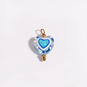 Blue heart-shaped glass pendant with concentric patterns and gold clasp detail