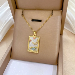 Macro shot of gold tarot The Moon necklace with blue crystal inlay in a jewelry box