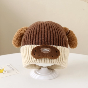 Detailaufnahme der braunen Strickmütze mit süßen Welpenohren und Stickerei für Kinder