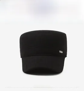 Front view of black wool flat top cap with short brim and small metal logo detail
