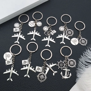Set of 9 silver travel keychains with airplane, globe and passport charms on black leather