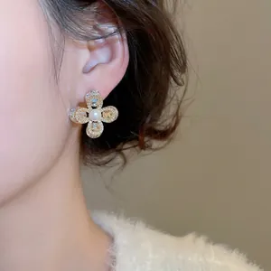 Élégantes boucles d'oreilles fleur dorées avec perle blanche et oxydes de zirconium