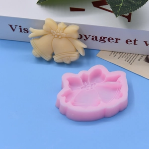 Macro detail of pink silicone bell mold and finished yellow craft ornament for DIY projects