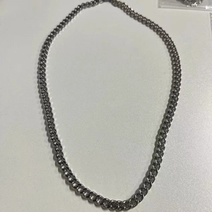 Detailed top view of a punk style silver stainless steel Cuban chain necklace on white