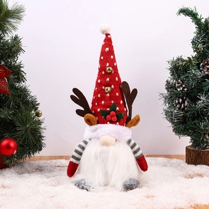 Détail d'un gnome de Noël rouge avec bois de renne et clochettes dans un décor de neige