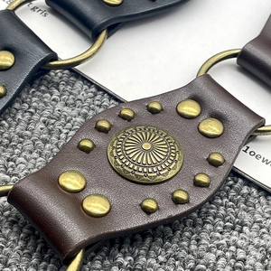 Detail of vintage Y2K leather belt with bronze rivets and sunflower metal buckle