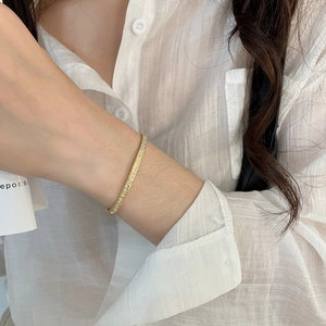 Detail of 18k gold plated honeycomb bracelet with zircon insets on model wrist