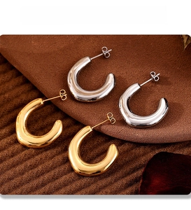 Detailed view of C-shaped irregular earrings showing gold and silver PVD plating texture