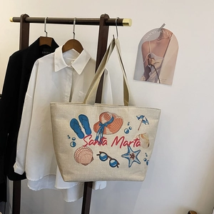 Detailed view of linen tote bag with beach-themed print and stylish red typography