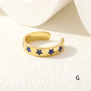 Detailed macro view of the gold-plated open ring with vibrant blue star patterns