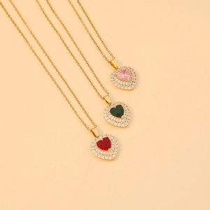 Détail de pendentifs cœur en rose, vert et rouge avec cristaux sur chaînes dorées