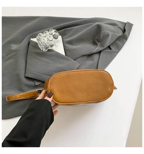 Detail of vintage brown oil wax leather bucket bag with oval base and smooth finish