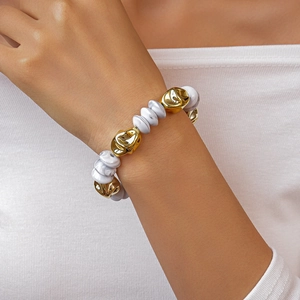 Close-up of chunky bracelet featuring gold irregular beads and marble textured discs