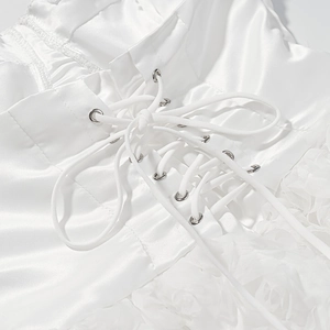Detail of white satin dress featuring elegant corset lace-up ribbons and 3D floral accents