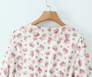 Detail of floral chiffon dress with ivory base and pink floral Peter Pan collar