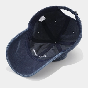 Detail view of cotton baseball cap interior featuring washing label and metal buckle