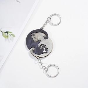 Detail of interlocking Yin Yang cat keychains in black and silver polished metal finish