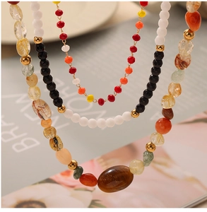 Macro shot of multi-layer beaded necklace featuring natural agate and colorful stones