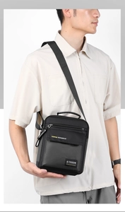 Close-up of a black nylon crossbody bag featuring the FASHION logo and a zipper detail