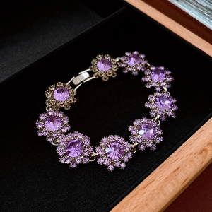 Macro shot of a floral crystal bracelet with purple stones in a premium jewelry gift box