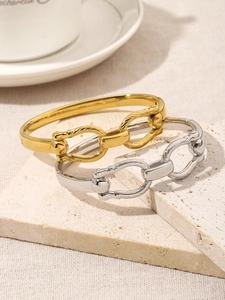 Detail of 18K gold and silver double ring bracelets with textured link design on stone