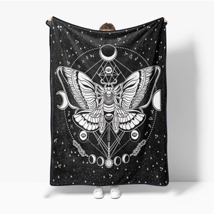 Macro view of soft flannel blanket featuring mystical moth and celestial zodiac patterns