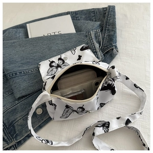 Detailed interior of a white butterfly print crossbody bag showing storage capacity