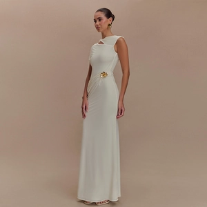 Detail of white one-shoulder maxi dress with gold flower buckle and elegant draping
