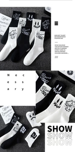 Detailed close-up of knitted crew socks with black and white graffiti bear and smile prints