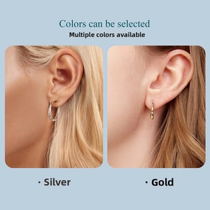 Close-up of silver and gold star-engraved hoop earrings on a model in a split-view