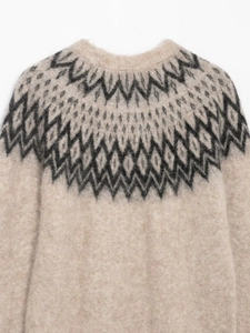 Close-up of beige alpaca knit sweater featuring Nordic Fair Isle jacquard pattern on neckline