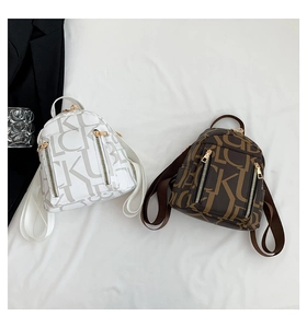 Close-up of white and dark brown monogram backpacks with gold zippers and PU leather detail