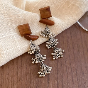 Détail de boucles d'oreilles vintage en bois avec glands ethniques et cloches ajourées