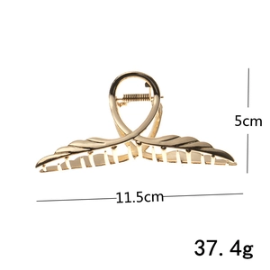 Detail showing gold metal wing hair claw clip dimensions 11.5cm width and 5cm height