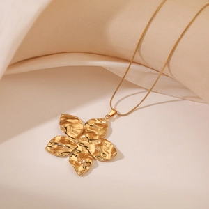 Elegant gold-plated sunflower pendant necklace with hammered texture on beige fabric