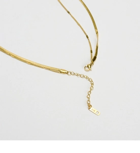 Close-up of double-layer gold snake chain with lobster clasp and K18 engraving detail