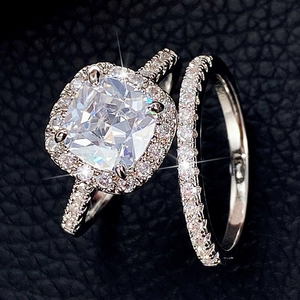 Macro shot of cushion cut halo zircon rings with micro-pave diamonds on black leather