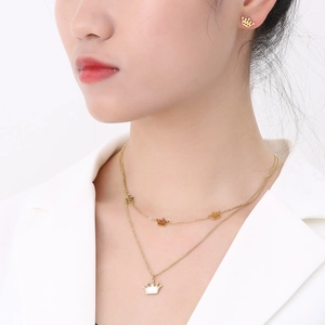 Detail view of a double-layer crown necklace set with matching heart stud earrings