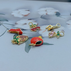 Close-up of assorted gold-plated fruit charms with enamel and cubic zirconia details