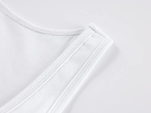Macro detail of white ribbed knit tank top showing high-quality stitching and fabric texture