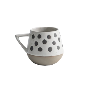 Minimalist ceramic mug with black dots, round shape and unglazed stoneware base