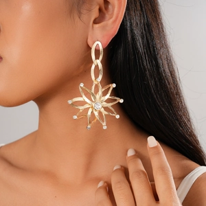 Luxury gold-plated cutout flower drop earrings with rhinestones on a female model