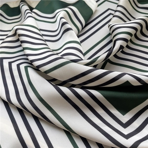 Detail shot of the silk scarf texture showing geometric stripes and elegant fabric folds