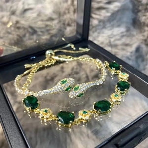 Gold-plated snake bracelet set with emerald green stones and adjustable sliding clasp