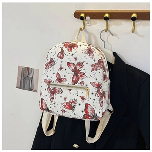 Close-up of white butterfly print backpack with golden zippers and front pocket