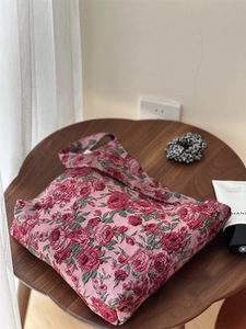 Détails du tissu jacquard rose bordeaux élégant sur un sac en toile à fleurs roses