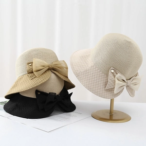 Détail d'un chapeau de paille d'été avec nœud en tulle élégant en kaki et beige